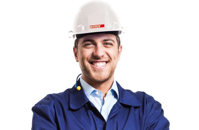 Een werknemer van Buchen Industrial Services in persoonlijke beschermingskledij met zijn armen gekruist terwijl hij lacht