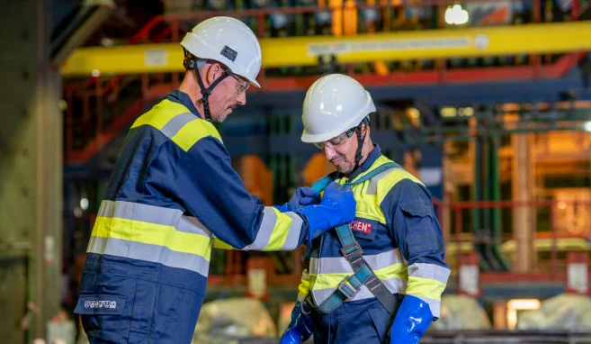 Werknemer van Buchen Industrial Services controleert het persoonlijk beschermingsmateriaal van zijn collega