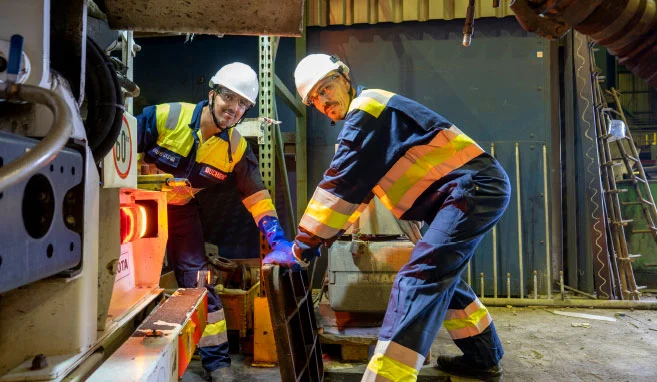 Twee industriële reinigers van Buchen Industrial Services maken zich klaar om een riool te inspecteren op een industriële locatie