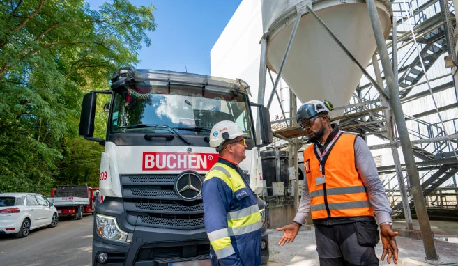 Overleg tussen een werknemer van Buchen Industrial Services en de klant op een industrieel terrein voor de combi zuigen hogedrukvrachtwagen.