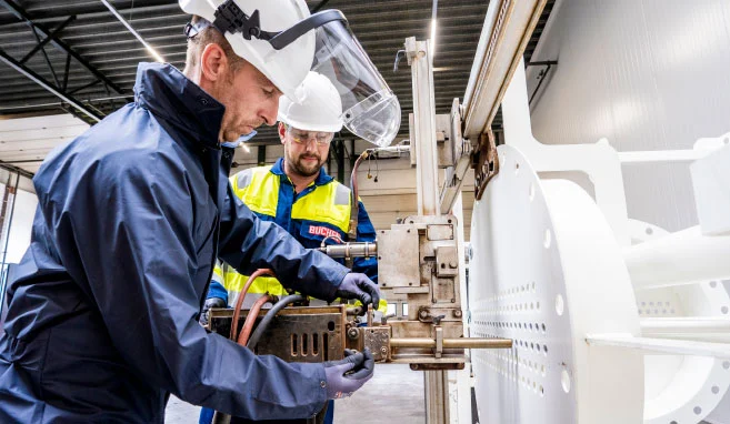 Twee industriële reinigers van Buchen Industrial Services gebruiken een bundelreiniger in het opleidingscentrum