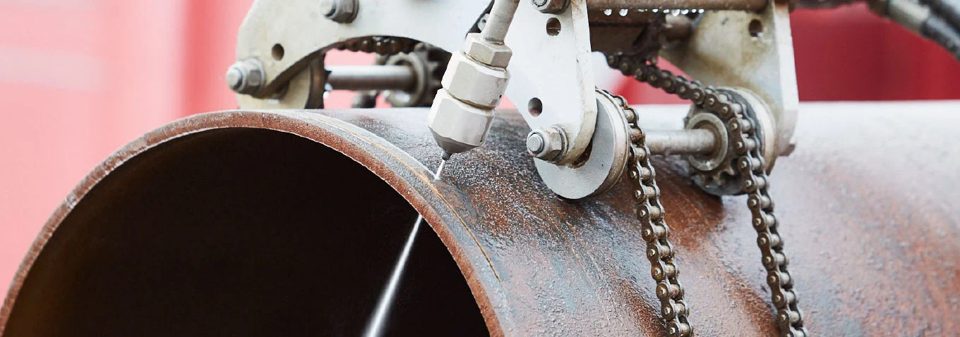 Close-up van het snijden van een buis met een hogedrukwaterstraal door middel van de koudsnijden-techniek van Buchen Industrial Services
